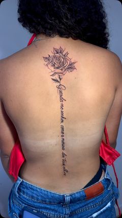 Rosa e frase em letra cursiva ao longo da coluna, em traço fino